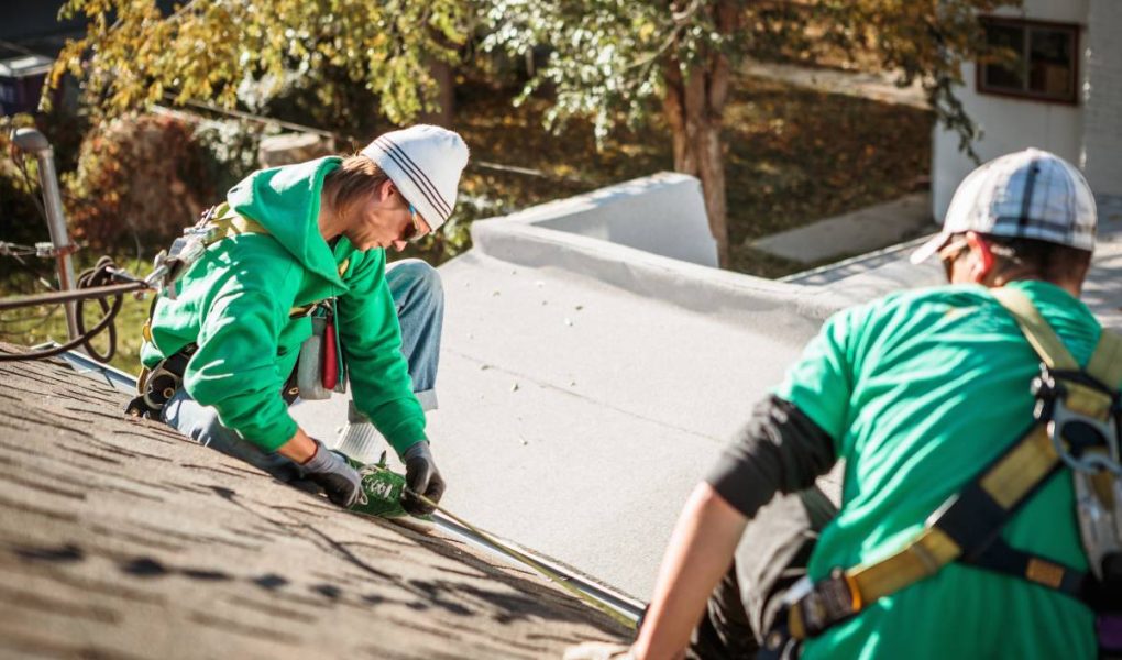 roof repairing crew members on roof of house