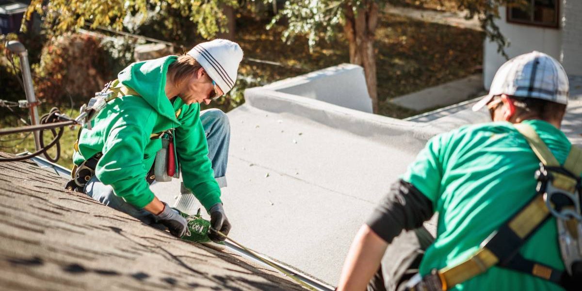 roof repairing crew members on roof of house