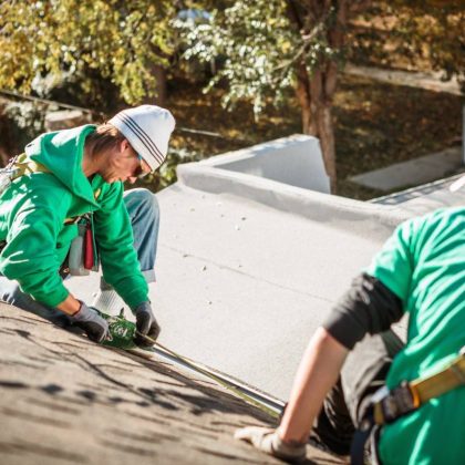 roof repairing crew members on roof of house