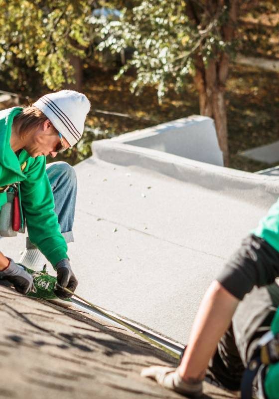 roof repairing crew members on roof of house