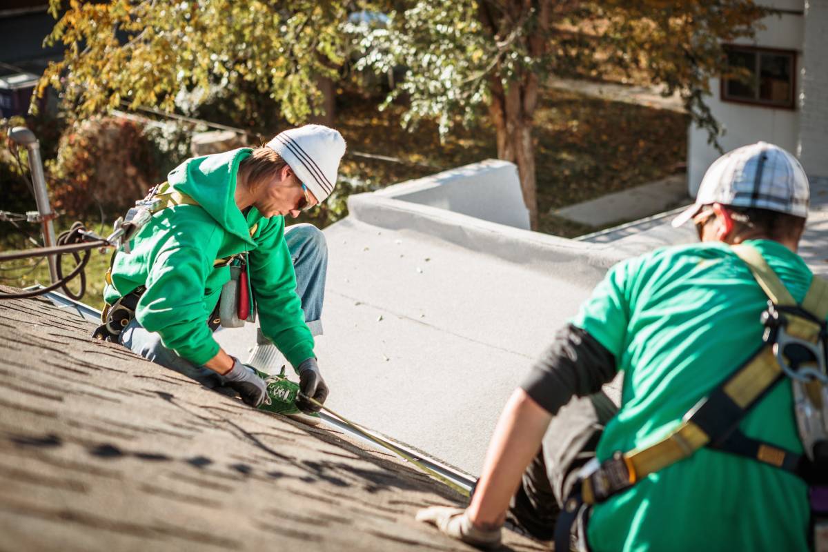 roof repairing crew members on roof of house